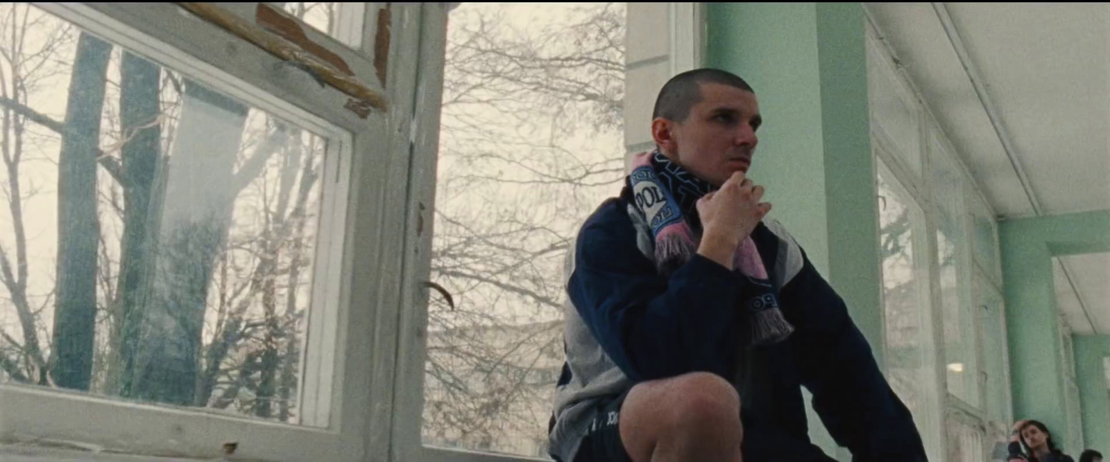 a man sitting on a ledge in front of a window