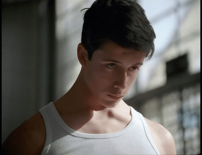 a man in a tank top looking at the camera