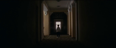 a person standing in a dark hallway at night