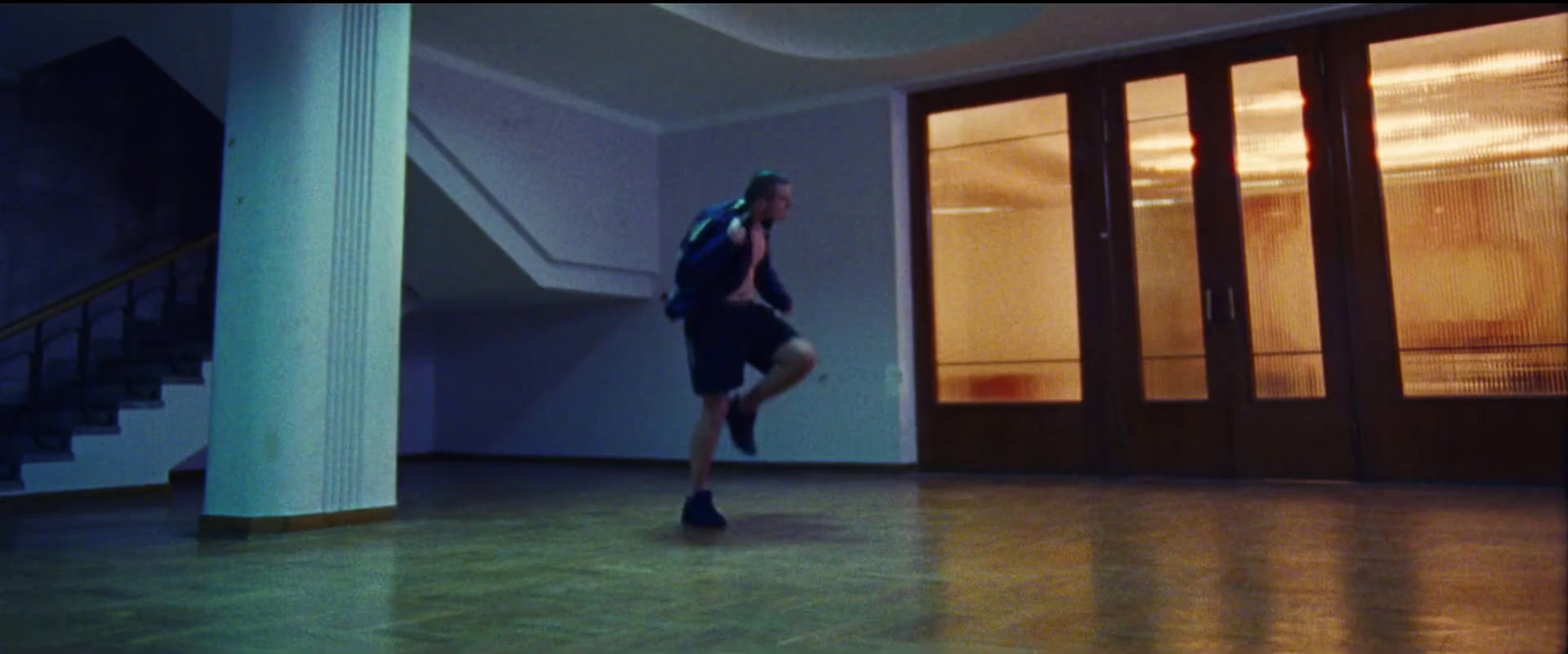 a man with a backpack is running in a room