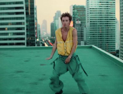 a man standing on top of a roof in a yellow shirt