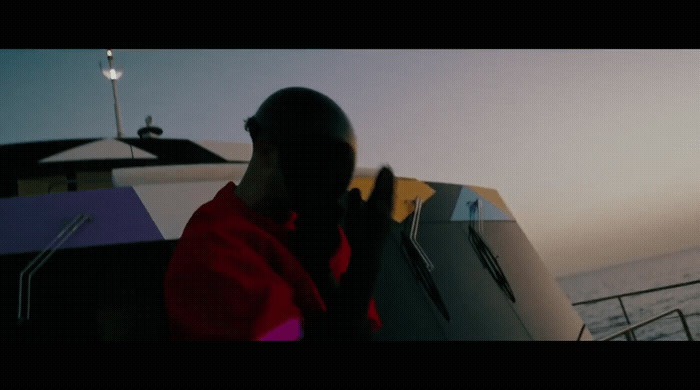 a man in a red jacket standing on a boat