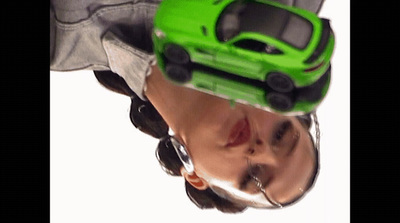 a reflection of a man with a green toy car on his head