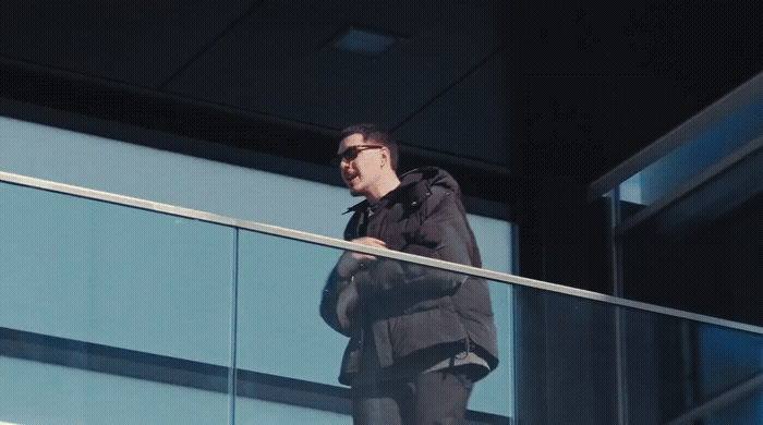 a man standing on a balcony with a skateboard