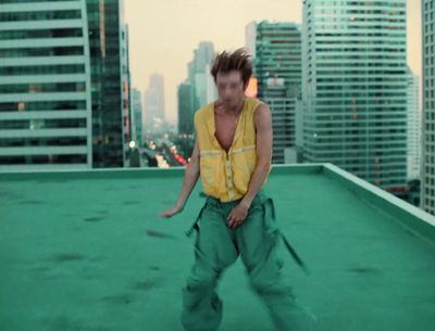 a man standing on top of a roof holding a tennis racquet