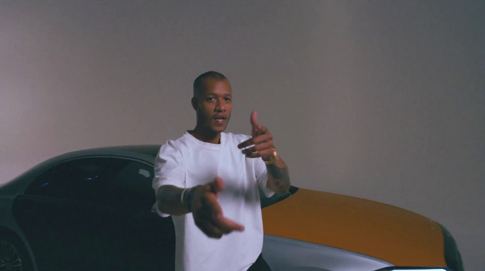 a man standing in front of a car giving a thumbs up