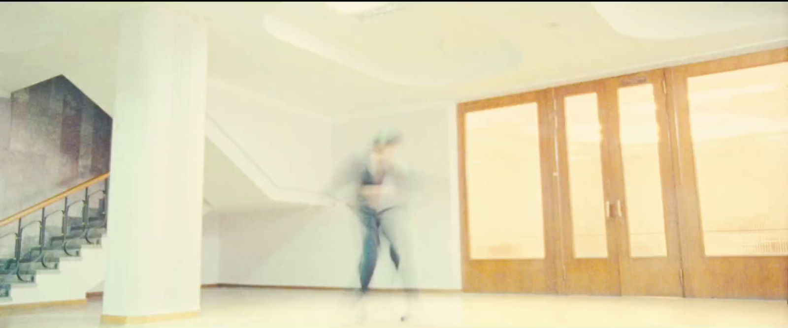 a blurry photo of a woman walking down a hallway