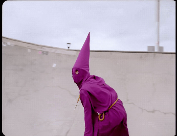 a person in a purple outfit is on a skateboard