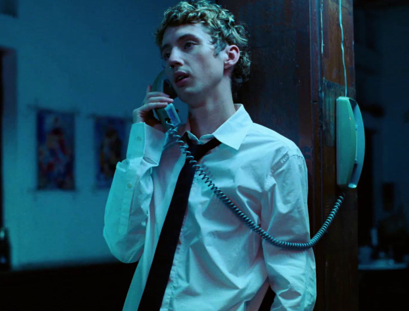 a man in a white shirt and tie talking on a phone