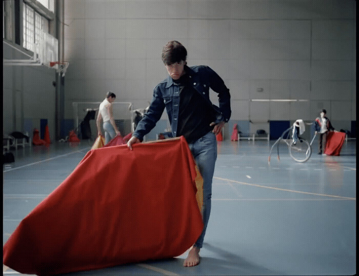 a man holding a large red object in a gym