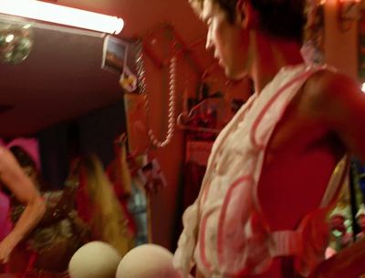 a man in a red and white dress standing in front of a mirror