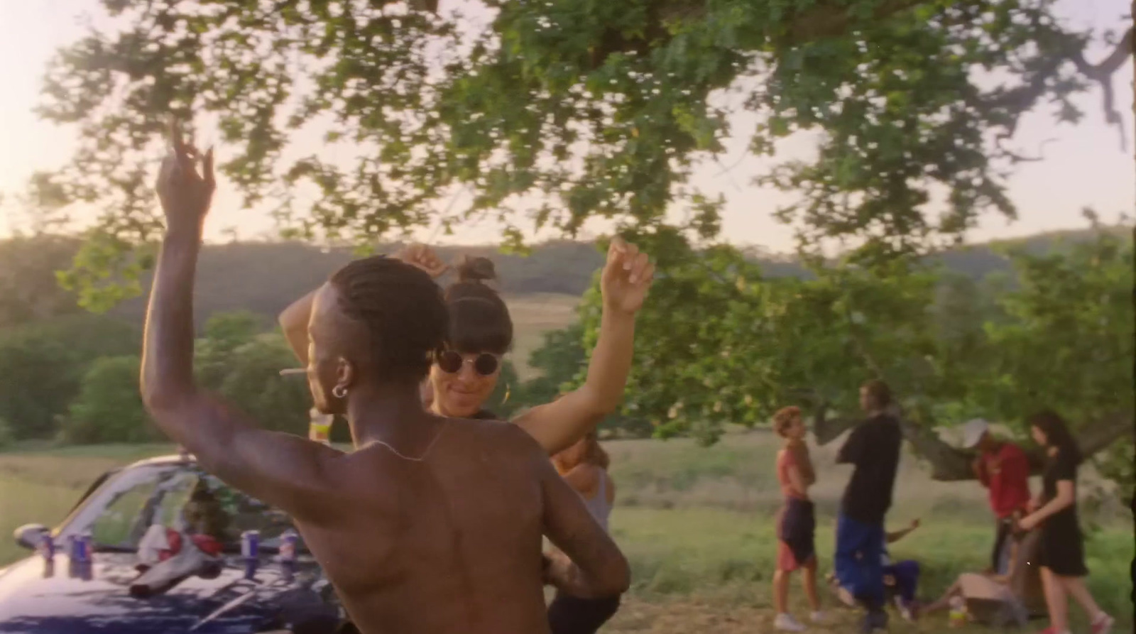 a man and a woman dancing in front of a car