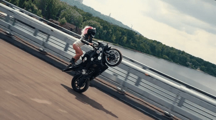 a person riding a motorcycle on a bridge