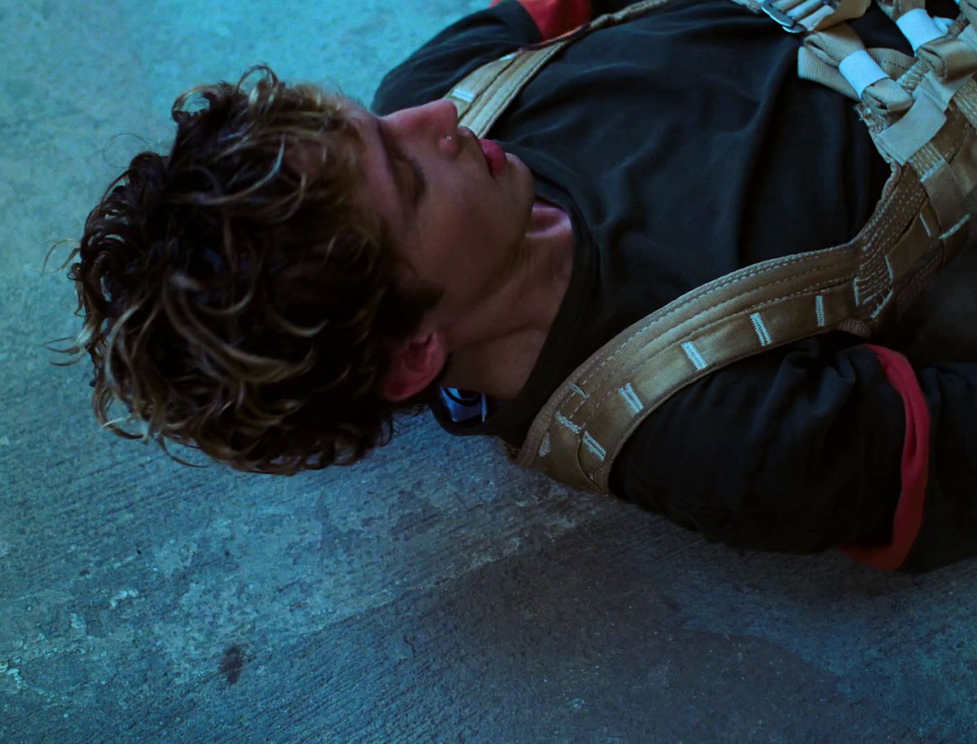 a man laying on the ground with a backpack on his back