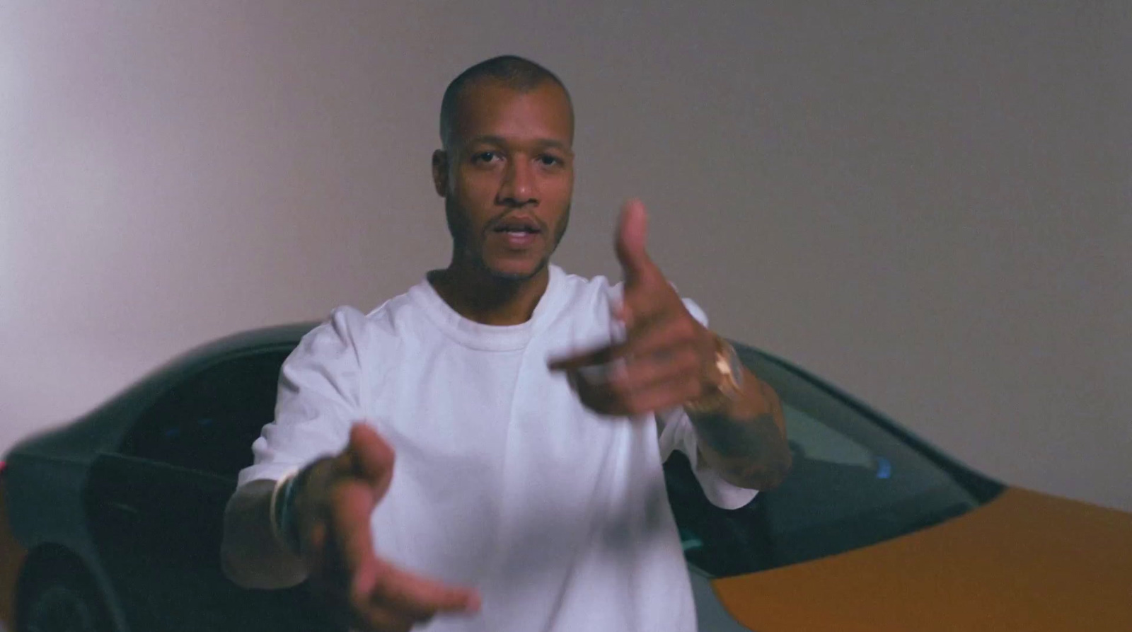 a man standing in front of a car giving a thumbs up