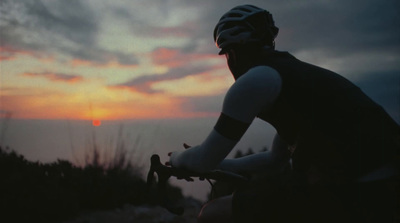 a man riding a bike down a dirt road