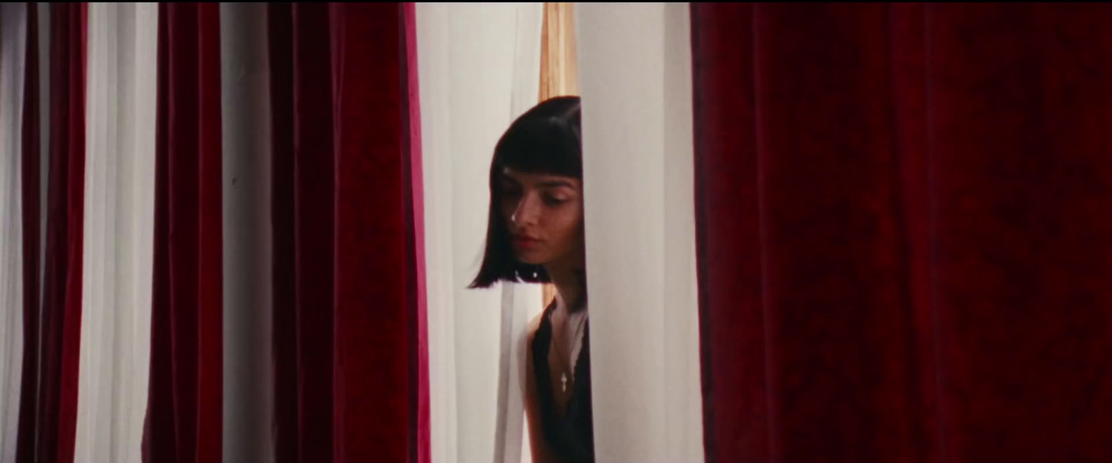 a woman peeking out from behind a curtain