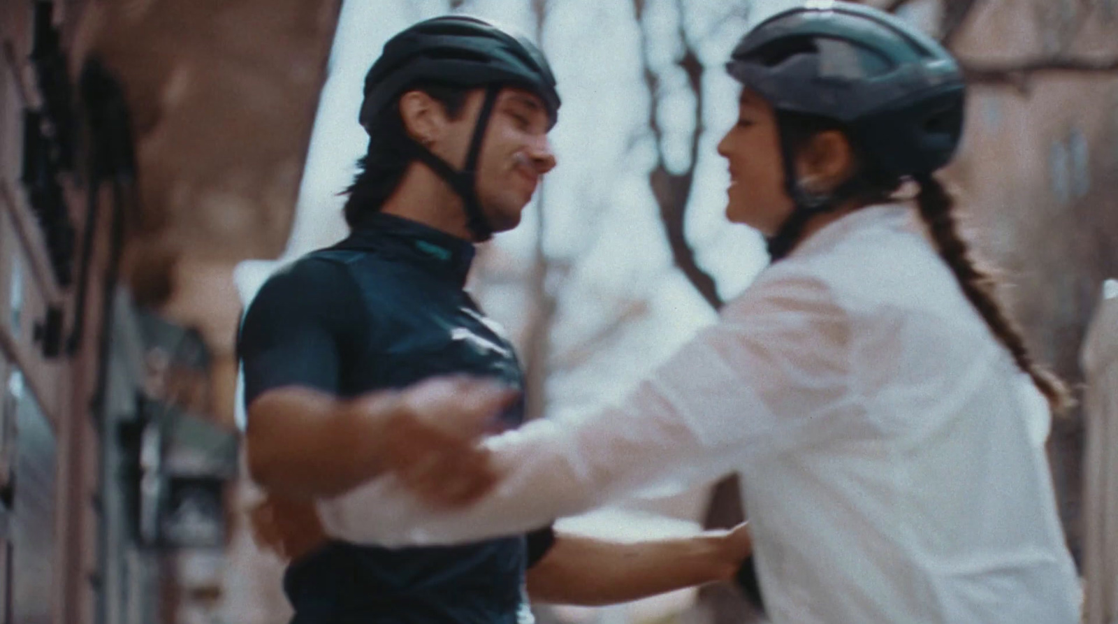 a man and a woman wearing helmets standing next to each other