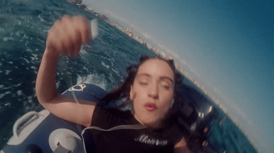 a woman riding on top of a boat in the ocean