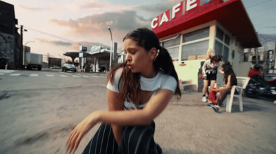 a young woman riding a skateboard down a street