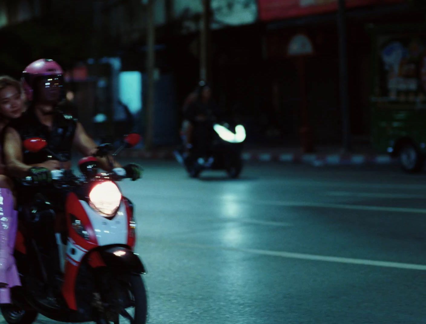 a couple of people riding on the back of a motorcycle