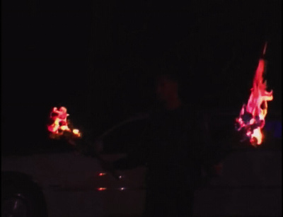 a man standing next to a car covered in christmas lights