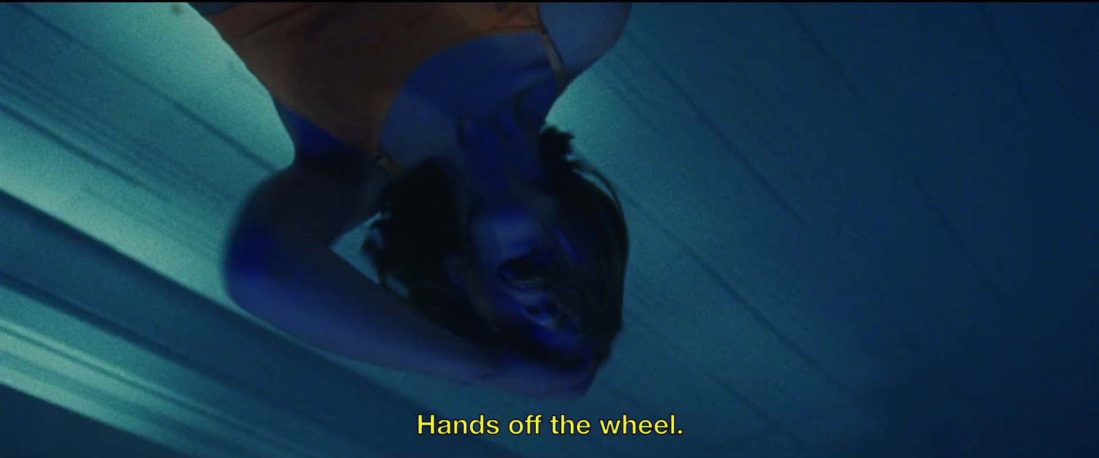 a woman in a blue dress with her hands on the wheel