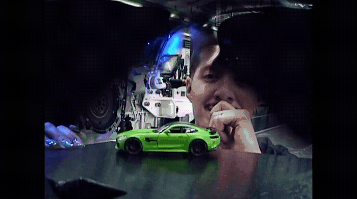 a green car is parked in front of a man