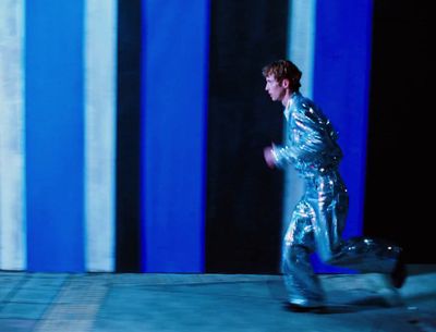 a man in a shiny suit is running