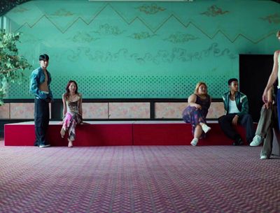 a group of people sitting on top of a red bench