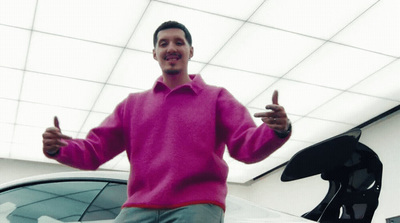 a man standing in front of a car giving a thumbs up