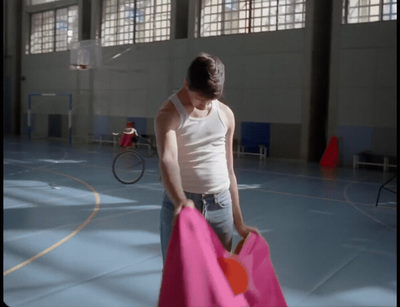 a woman holding a pink bag in a gym