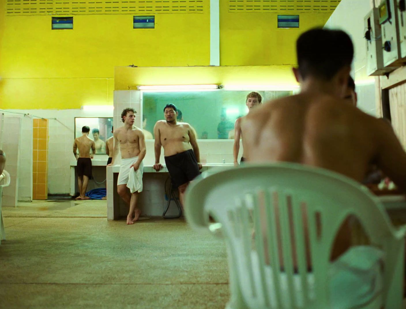 a group of men standing in a bathroom next to each other