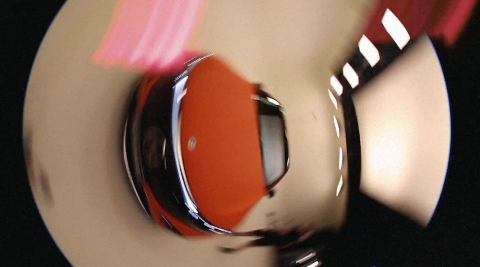 a red car is seen from above on a white plate