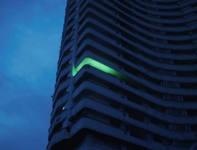 a tall building with a green light on it's side