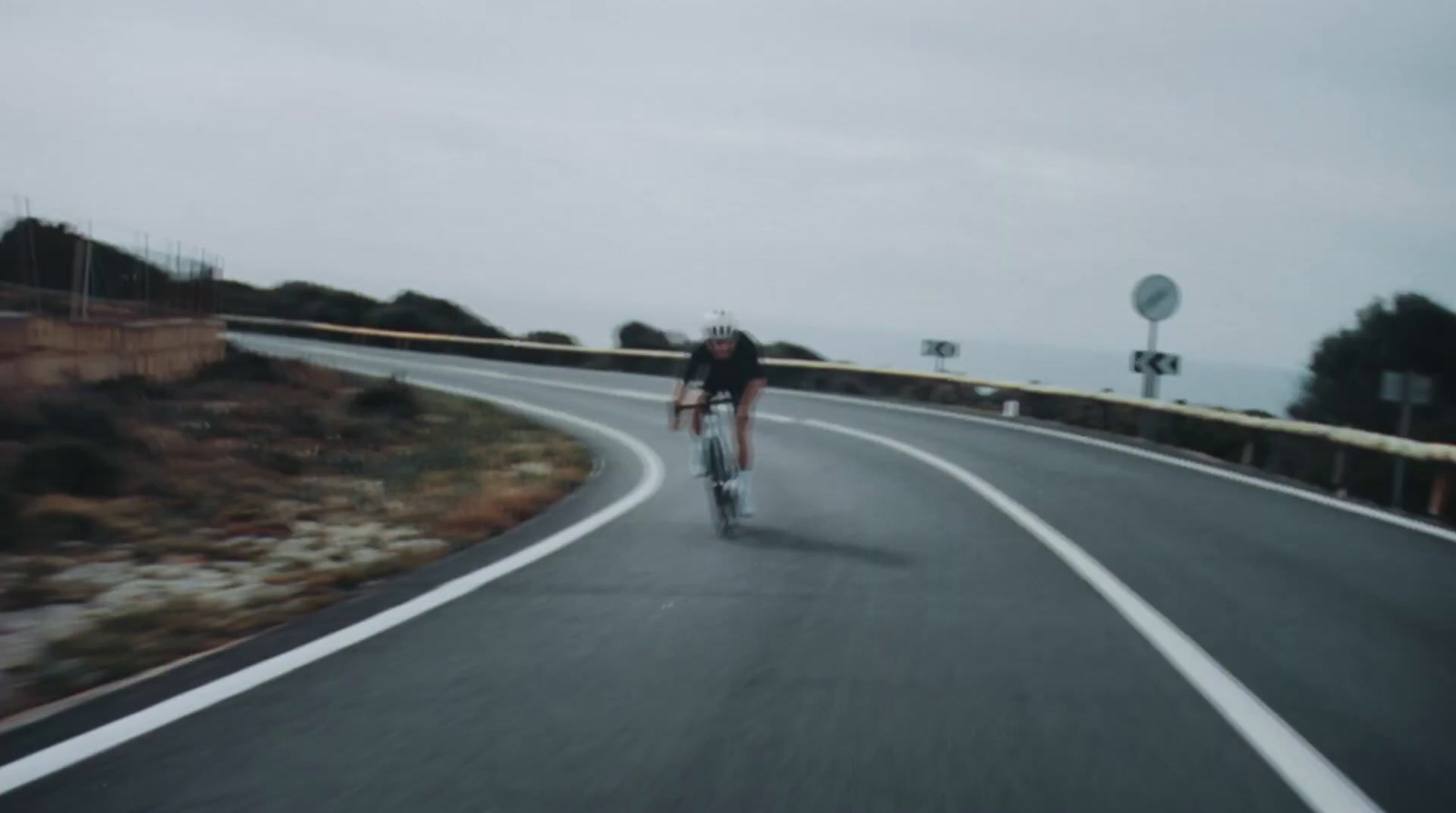 a man riding a bike down a curvy road