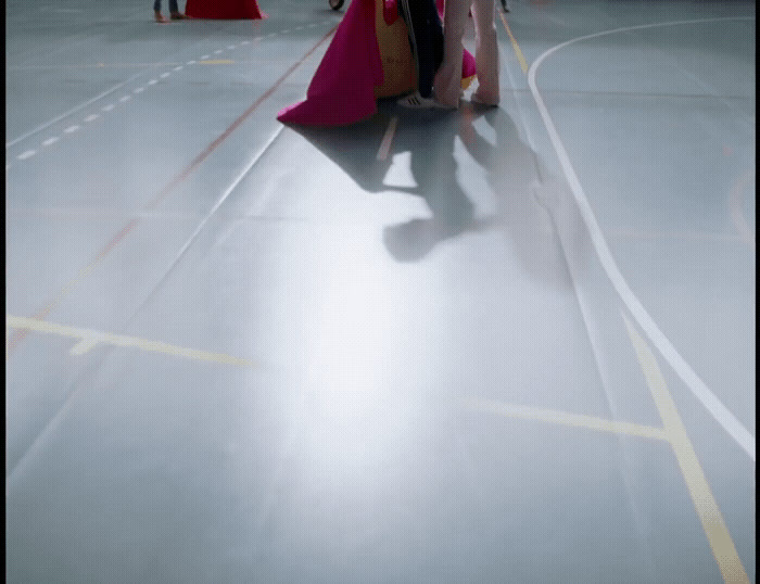 a woman in a pink dress is walking down the street