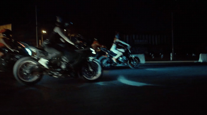 a group of people riding motorcycles at night