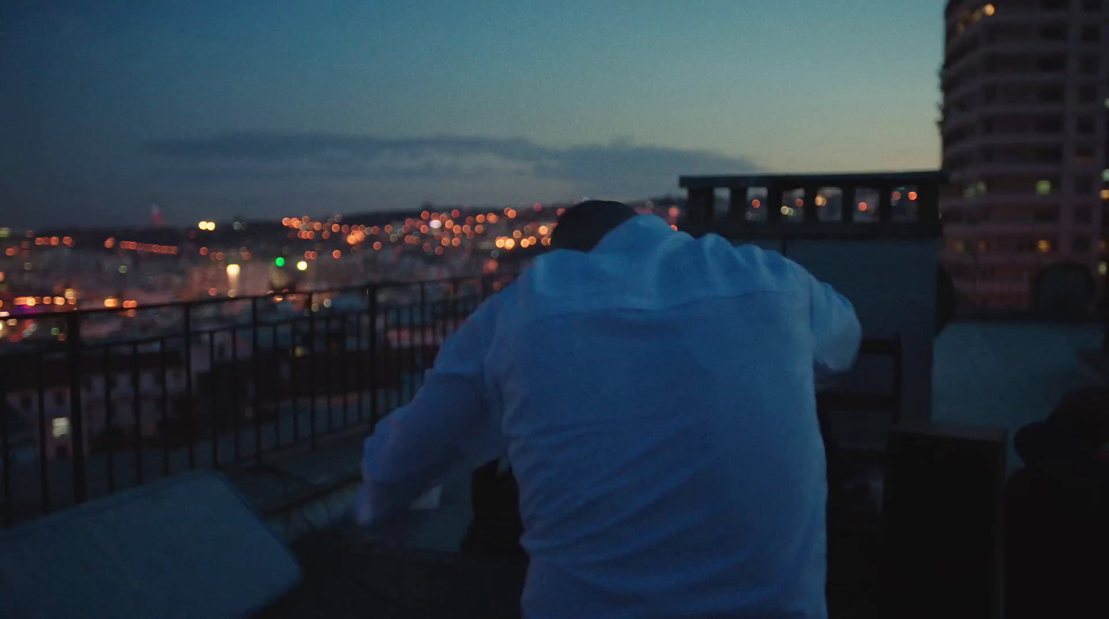 a man standing on top of a roof next to a tall building