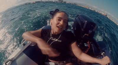 a woman riding a boat on top of a body of water