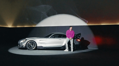 a man standing next to a car on a stage