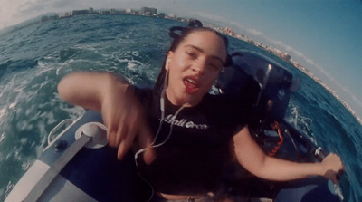 a woman riding on top of a boat in the ocean