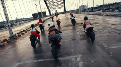 a group of people riding motorcycles across a bridge