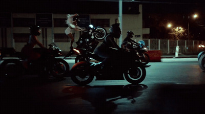 a group of people riding motorcycles at night