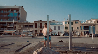 a man standing on top of a rock next to a street