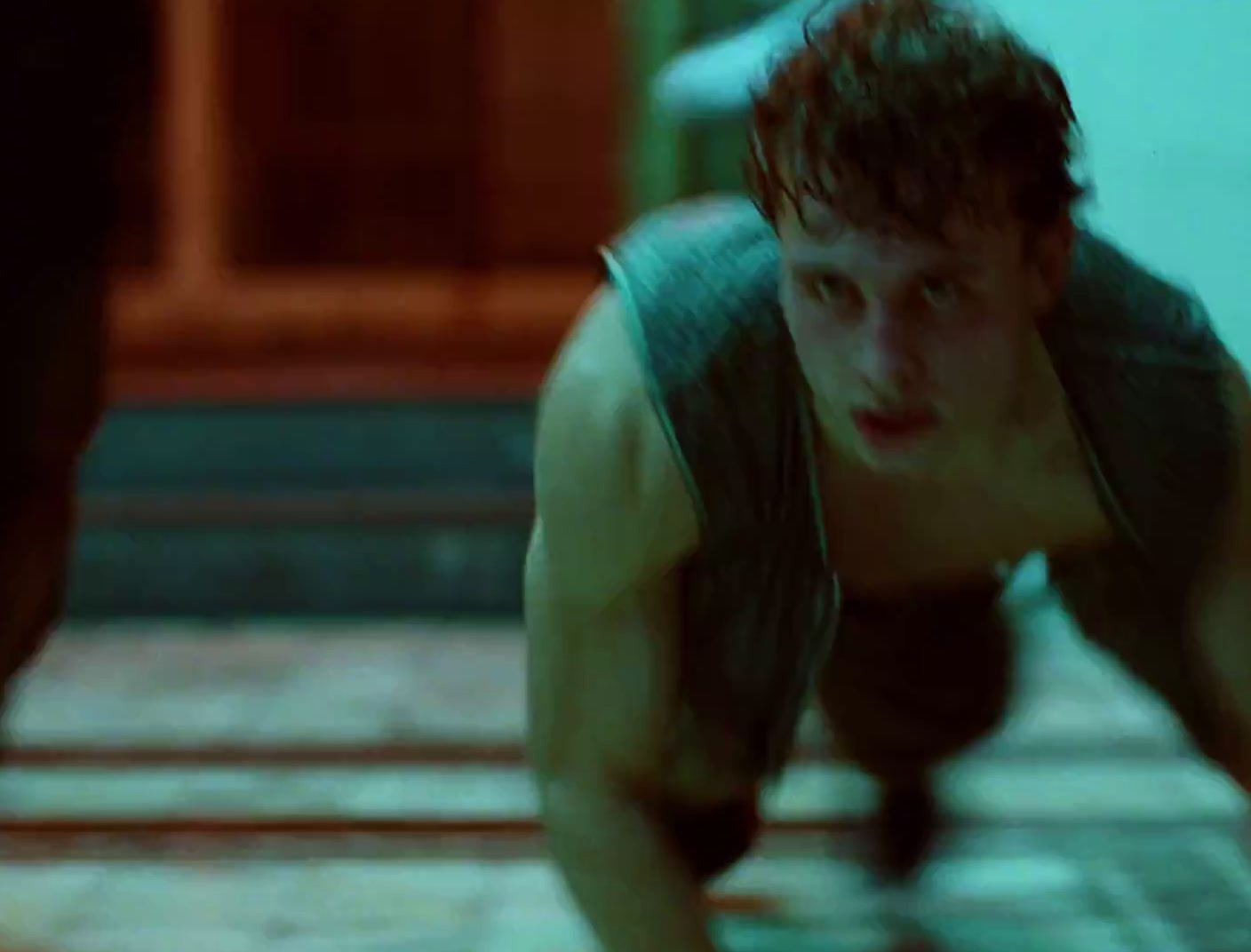 a man in a tank top crouching down on a tile floor