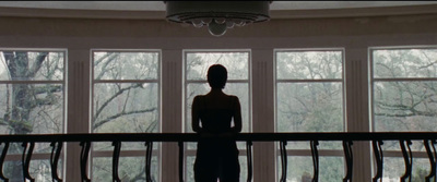 a woman standing in front of a large window