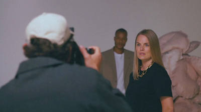 a woman standing in front of a man taking a picture