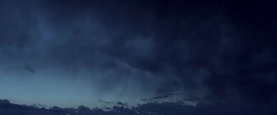 a plane flying through a cloudy sky at night