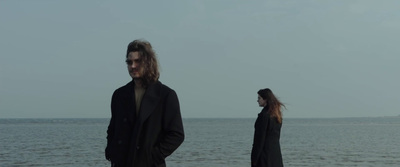 a man and a woman standing next to each other on a beach